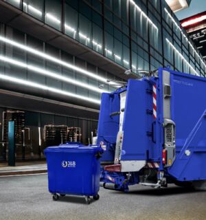 Large blue wheelie bin about to be loaded into the back of a recycling truck