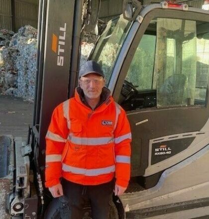 J&B Recycling forklift driver wearing PPE, stood in yard