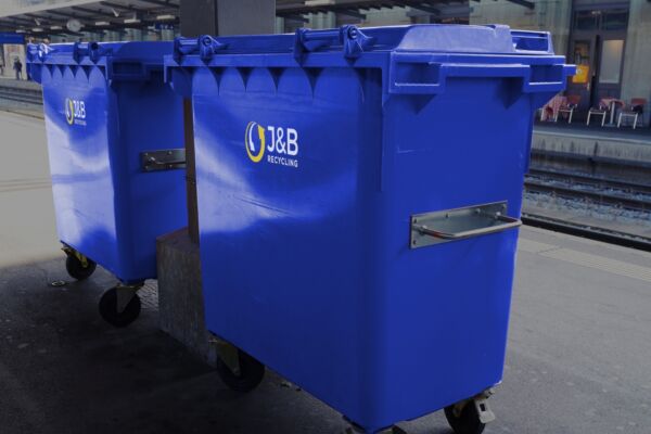 Large blue wheelie bins in an industrial setting with J&B recycling logo