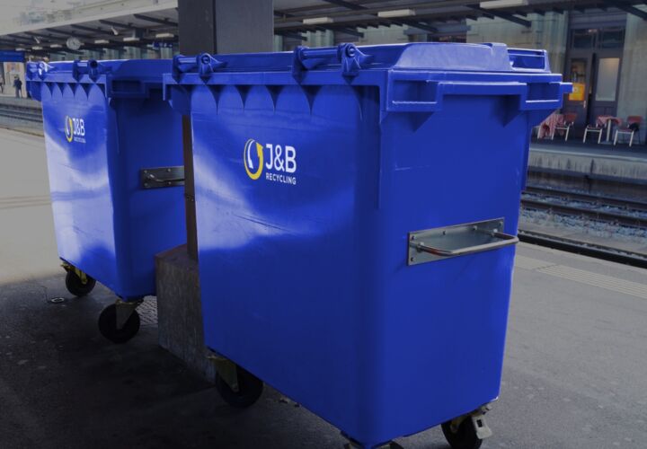 Large blue wheelie bins in an industrial setting with J&B recycling logo