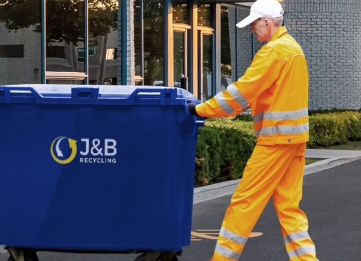 Bin man collecting large wheelie bin with J&B recycling logo