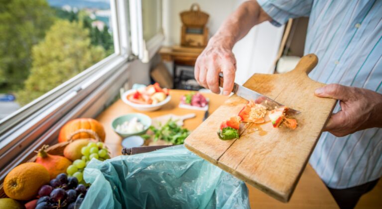 Food waste, photo of man with chopping board, putting food waste into compost caddy