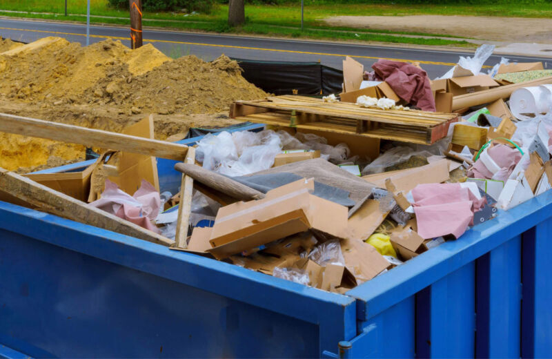 Photo of blue skip filled with rubble and construction waste