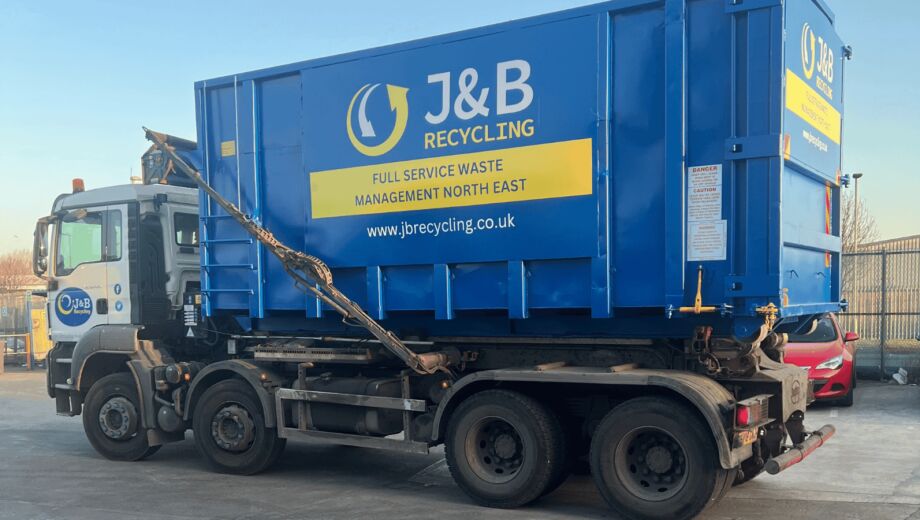 Large industrial skip being delivered on truck